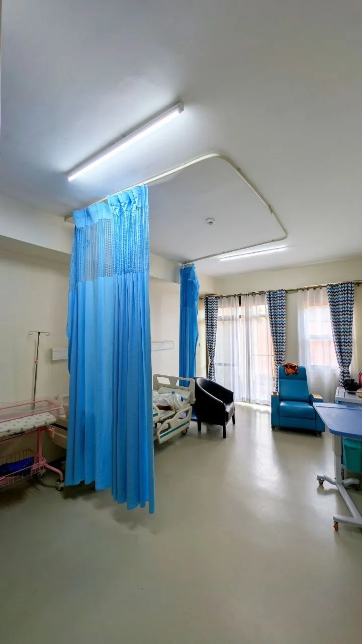 A clean hospital ward with blue privacy curtains